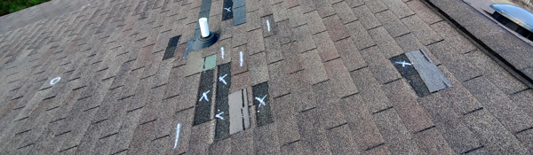 Traditional three tab shingles showing damage during inspection